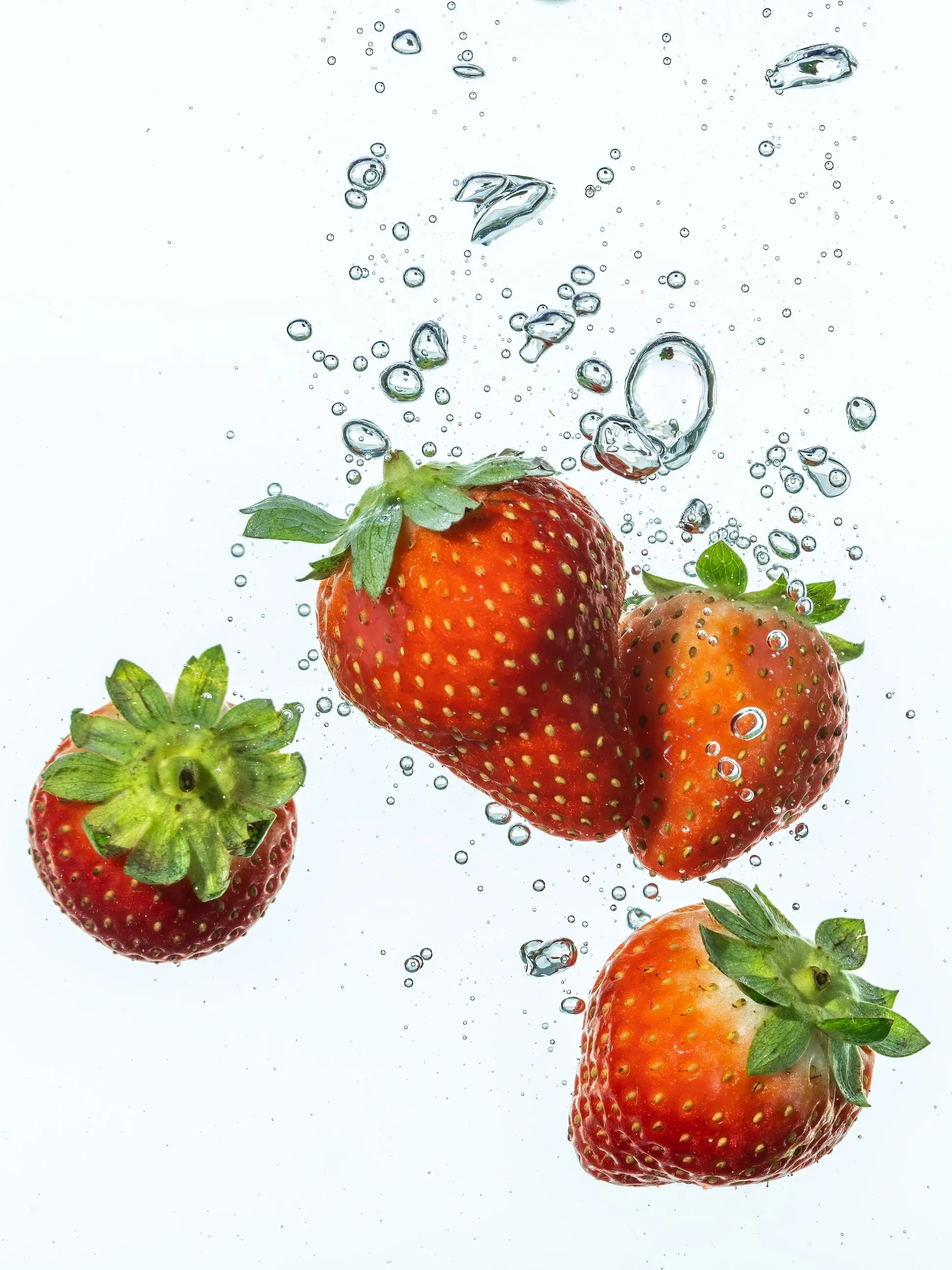 Fraises plongées dans l’eau, entourées de bulles